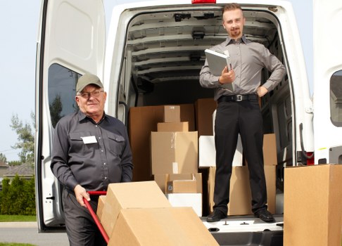 Removal van loading boxes at a city apartment entrance in France