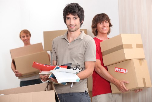 Removal workers using safe lifting techniques during loading