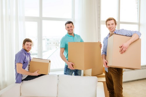 Relocation specialists moving desks and equipment in a French office